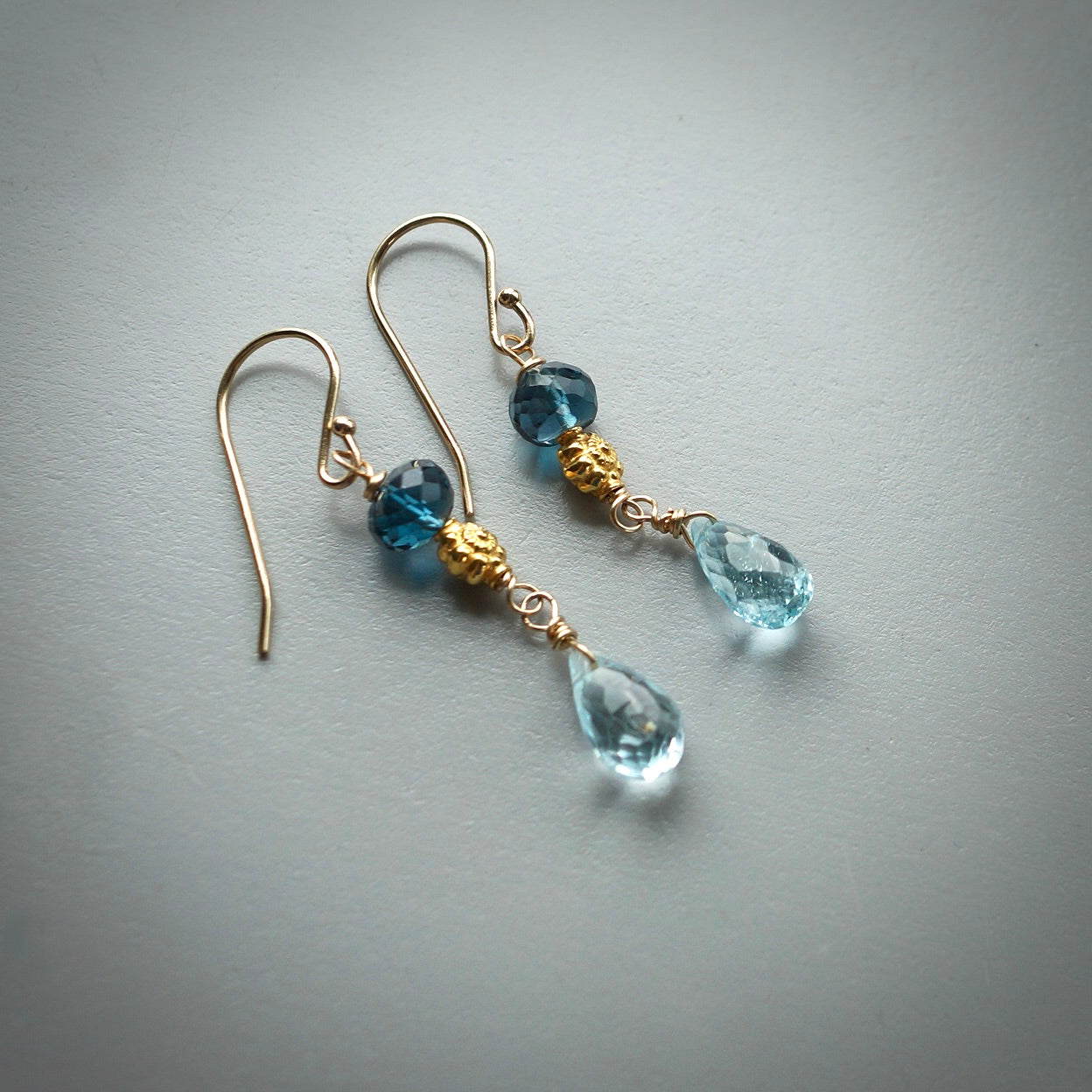 Solid gold earrings with blue topaz
