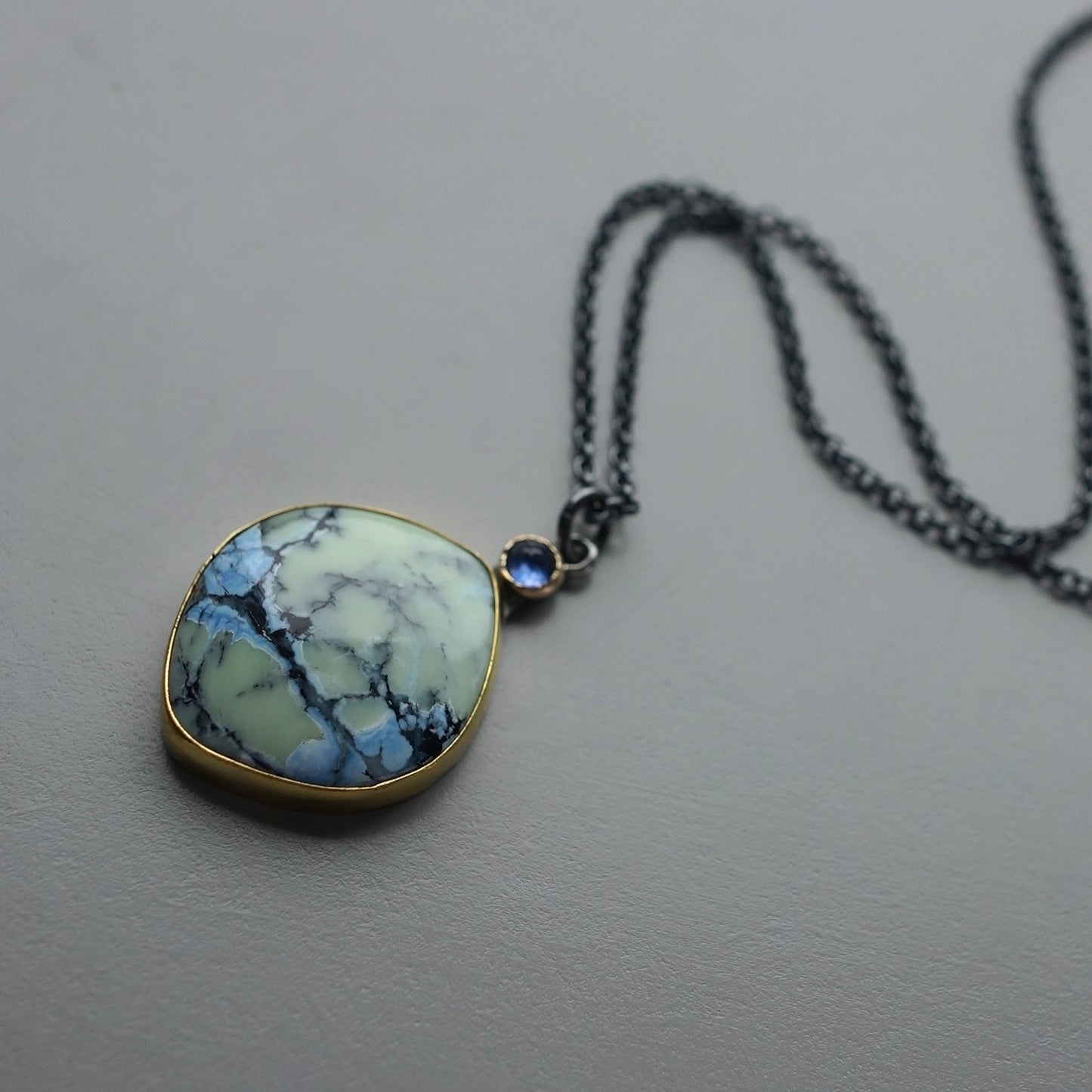 White Hotsonite and blue sapphire pendant