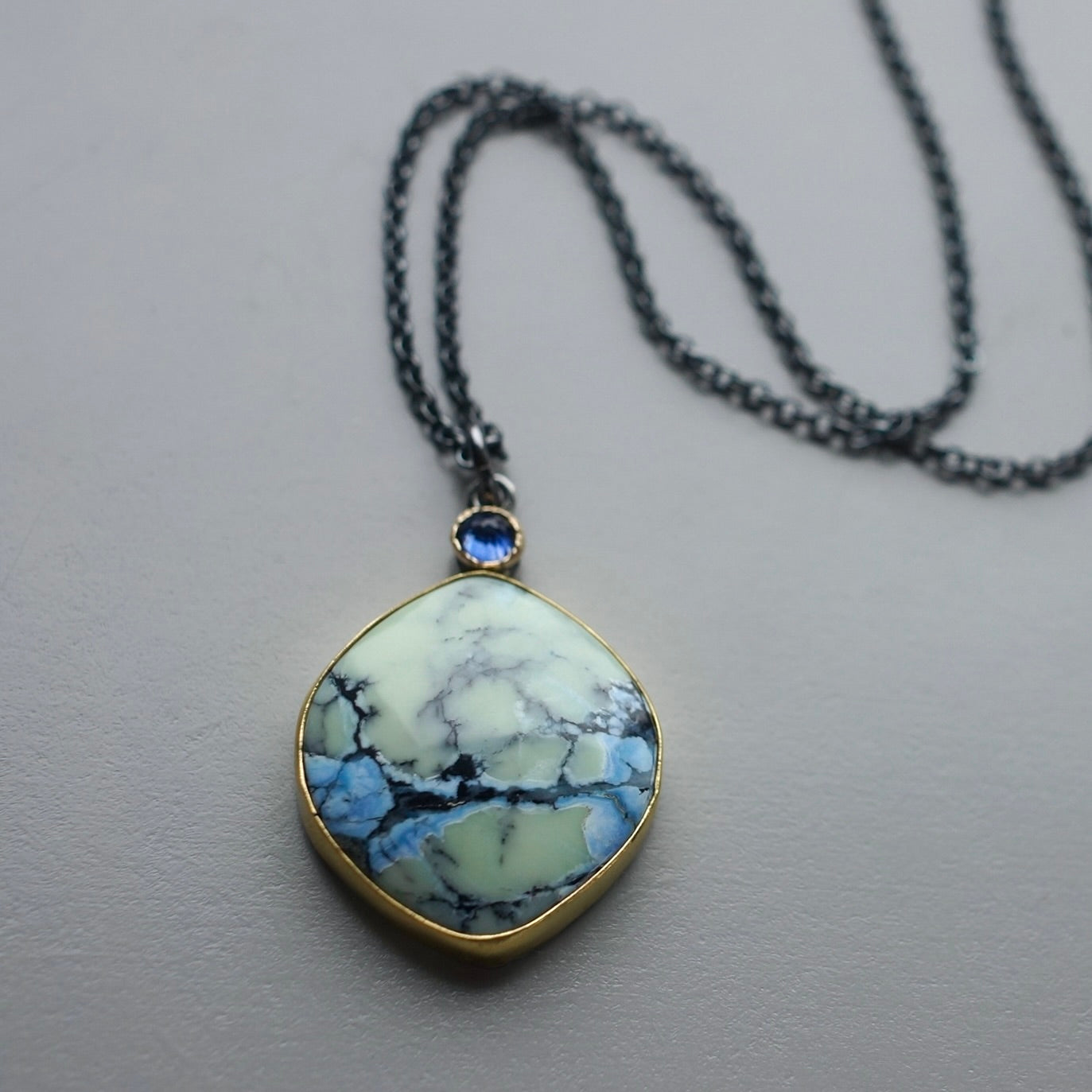 White Hotsonite and blue sapphire pendant