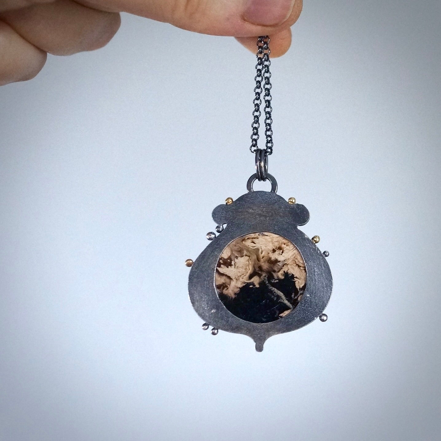 Fossil palm root and garnet pendant