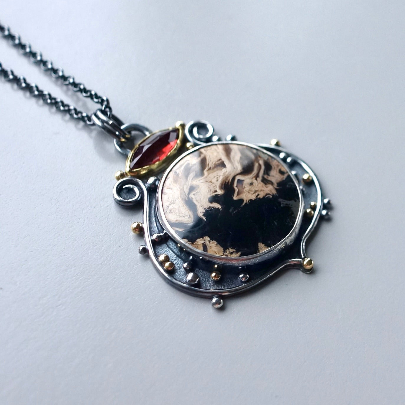 Fossil palm root and garnet pendant